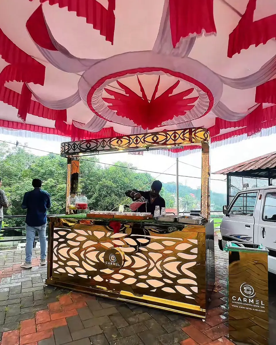 Carmel's gold welcome-drinks counter under a festive canopy